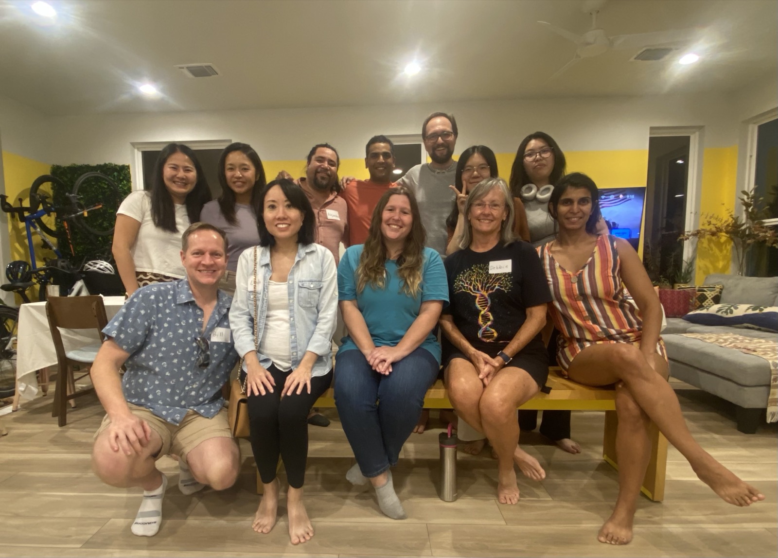 A group of members gathered together, smiling, after a Family Origin Potluck gathering.