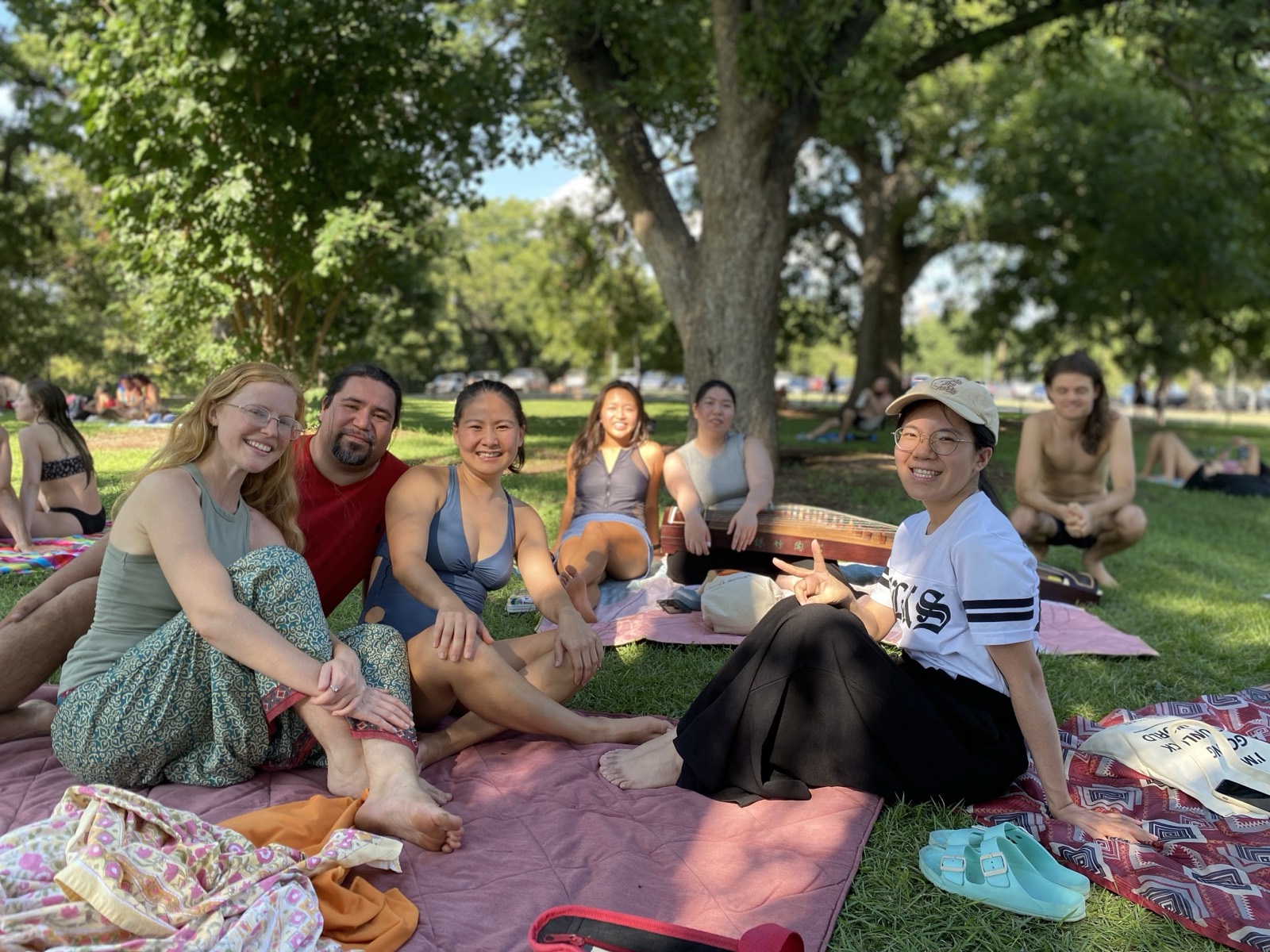 Members relaxing together on blankets in a park during a casual community hangout.